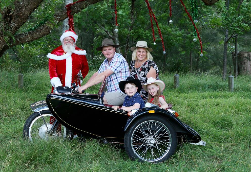 Merry Christmas: The Doolan Family (Nicole, Doug and their children Chloe and Paddy)  have their photo taken with Santa in the park. Photo Sharon Benson Photography