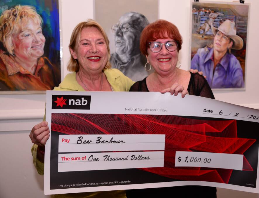 Lindy Dupree with artist Bev Barbour in front of Bev's winning drawing of Grahame Stelzer. Photo Adele Compton