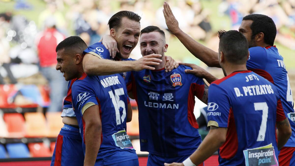HAPPY DAYS: Captain Nigel Boogaard (second from left) is mobbed by teammates after scoring the Jets opening goal in the 2-0 triumph over Melbourne Victory at McDonald Jones Stadium on Saturday. Picture: Darren Pateman (AAP)