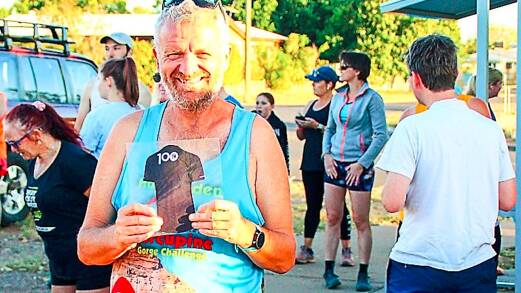 The author celebrates his 100th parkrun in Mount Isa last weekend with a cardboard cutout of the 100 run t-shirt and followed it up by swiftly ordering the real thing online.