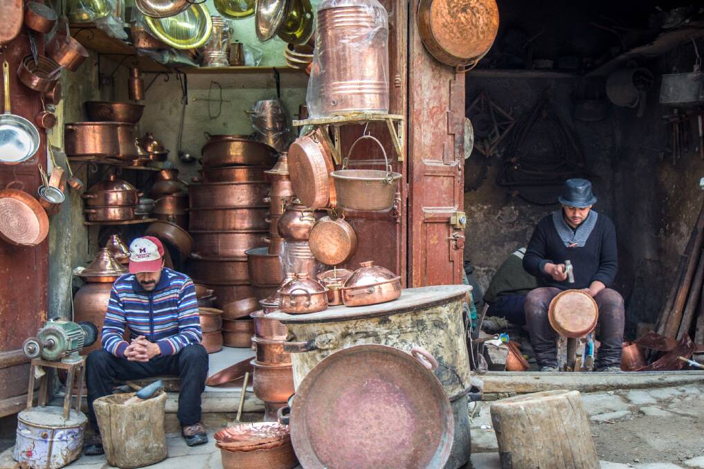 Workers make copper pots by hand in one of the souks of Fez. Picture: Michael Turtle