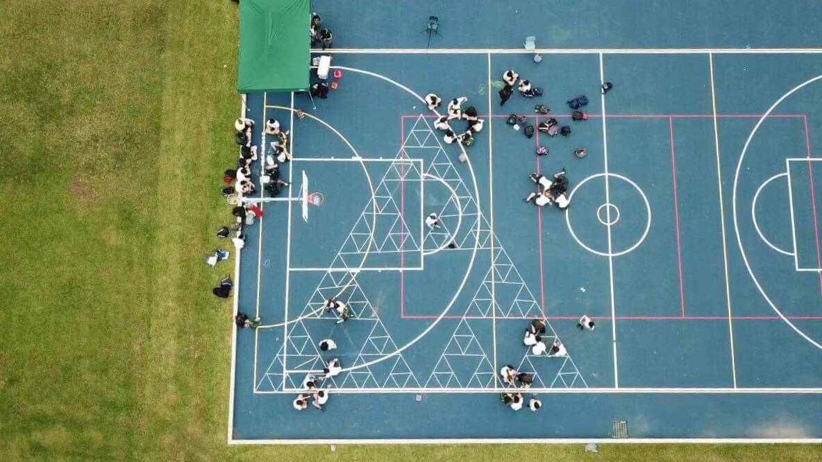 Around 93 kilograms of 20-cent coins were used to create the Sierpinski triangle on the basketball court at St Clare's High School.