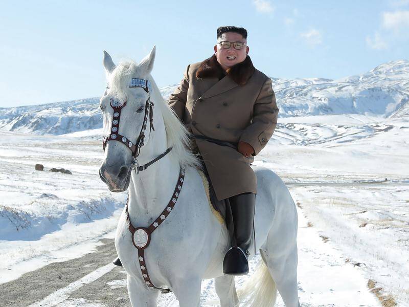 North Korean media photos show Kim Jong-un riding a white horse to climb a Mount Paektu.