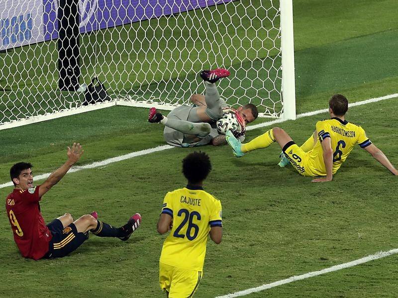 Sweden goalkeeper Robin Olsen hangs on to deny Spain's Gerard Moreno a late winning goal.