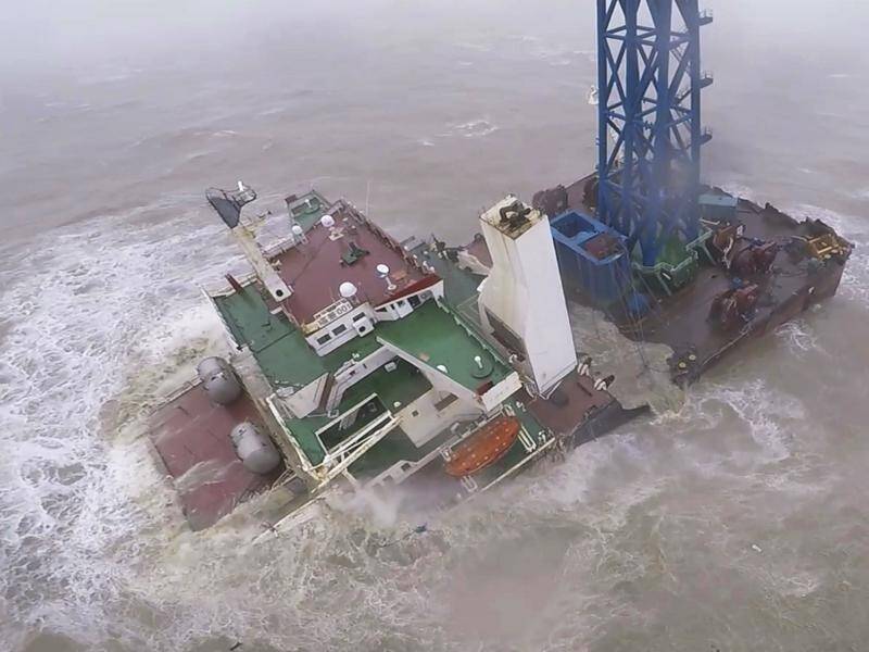 Two dozen crew are missing after a ship snapped in half during a tropical storm off Hong Kong.