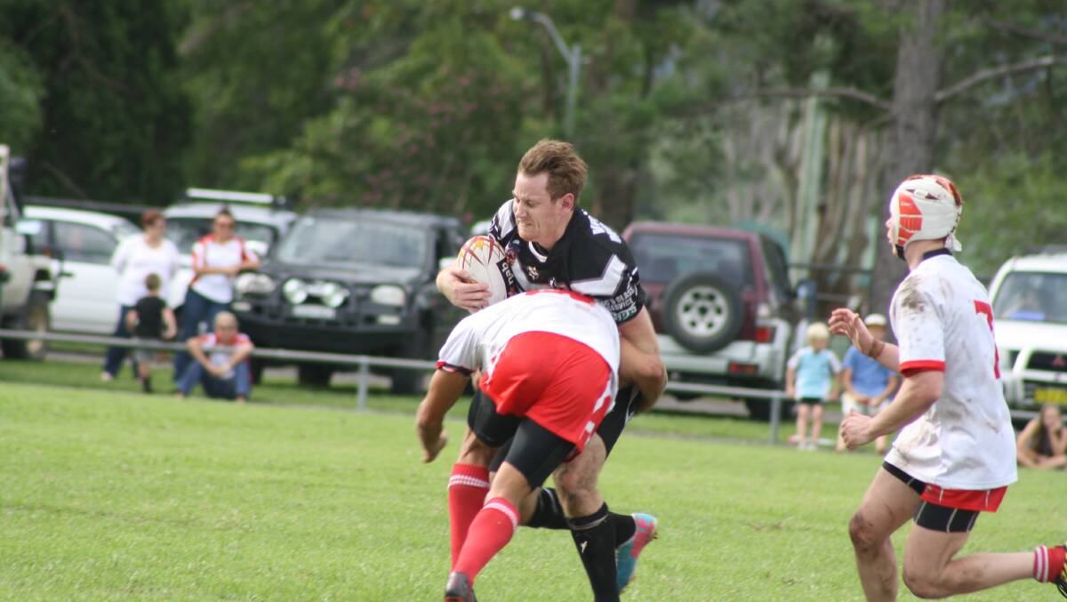 Scott Wratten is tackled by a Roos defender.