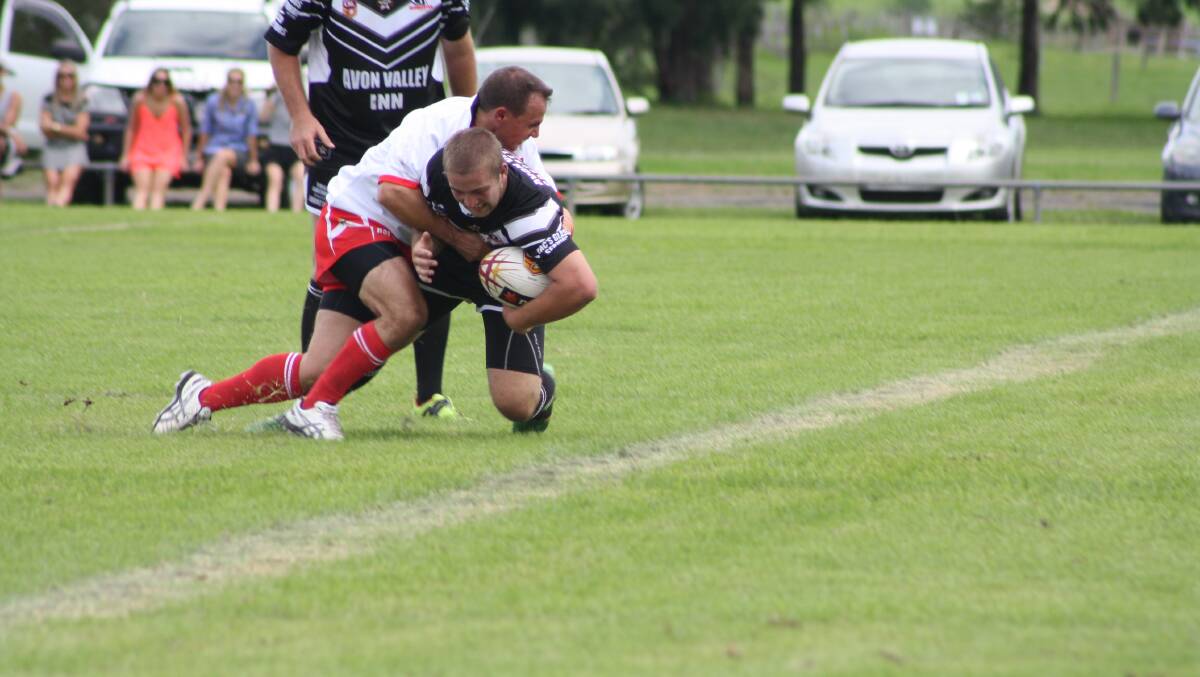 Mitch McDonald is tackled by a Karuah defender.