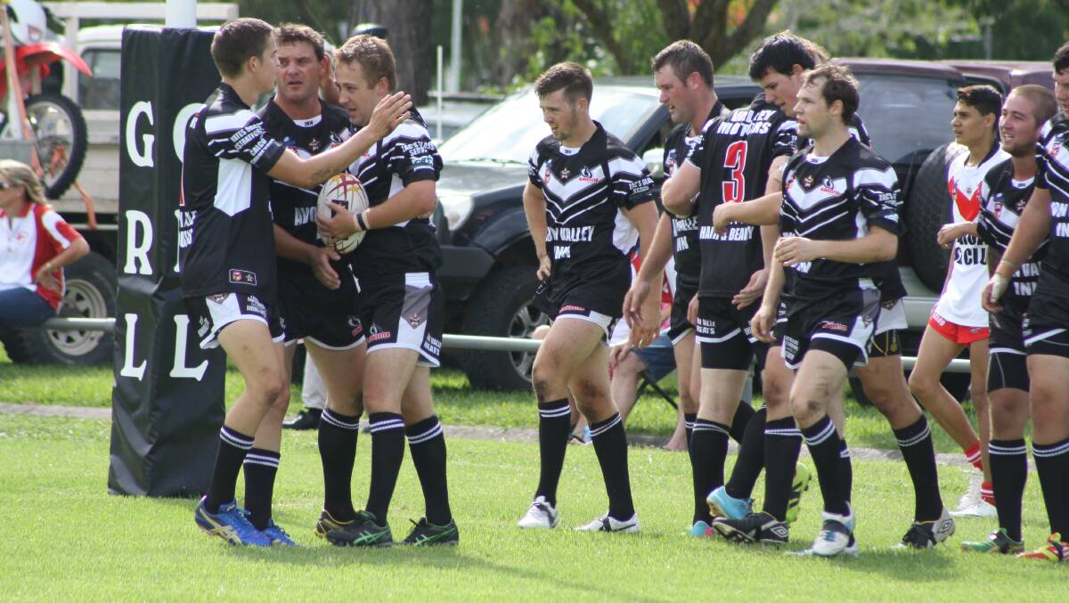 The Magpies players congratulate half back Hayden Tull after he scored the opening try of the match. 